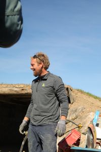 Ben Reinhold smiles while standing in front of the Pol family farm's soon-to-be earth-sheltered sheep hut. (National Geographic )