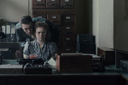 A SMALL LIGHT - Silberbauer, played by Daniel Donskoy, threatens Bep, played by Sally Messham, as seen in A SMALL LIGHT. (Credit: National Geographic for Disney/Dusan Martincek)