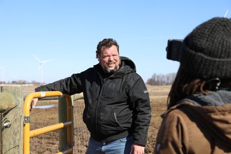 Charles Pol checks on the animals in the Pol family farm's muddy animal pasture, now that spring has arrived. (National Geographic)
