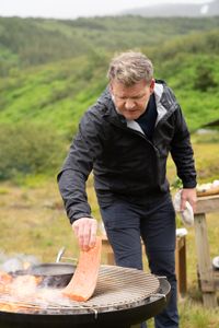Iceland - Rain falls as Gordon Ramsay grills fresh salmon during the final cook in Iceland. (Credit: National Geographic/Justin Mandel)