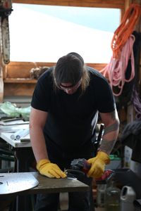 With the help of his neighbor, David Squibb constructs a new fairlead for his skiff. (National Geographic/Wayne Moss)