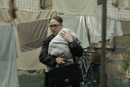 A SMALL LIGHT - Jan Gies, played by Joe Cole, escapes with a valuable package in A SMALL LIGHT. (Credit: National Geographic for Disney/Dusan Martincek)