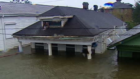 In the aftermath of Hurricane Katrina, houses are flooded up to their roofs. (KTVT-TV)