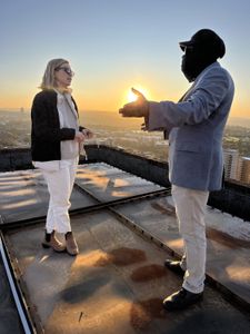 Mariana van Zeller and Ben discuss the world of scamming while on a rooftop in Johannesburg. (National Geographic for Disney)
