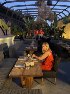 Mariana van Zeller sits at a table preparing for dinner with Ricardo and Daniela. (National Geographic for Disney)