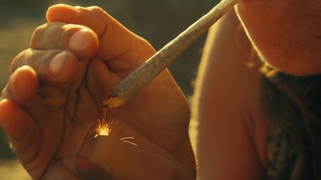 Barbara lights a hash cigarette on the coast of Portugal. (National Geographic)