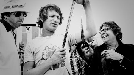 Steven Spielberg looks at a film strip with crew on the set of Jaws. (Courtesy of Universal Studios Licensing LLC)