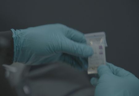 The hands of a CBP agent wearing blue gloves hold evidence in St Thomas, USVI. (Lucky 8 TV/Paul Taggart)