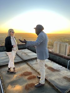 Mariana van Zeller and Ben discuss the world of scamming while on a rooftop in Johannesburg. (National Geographic for Disney)