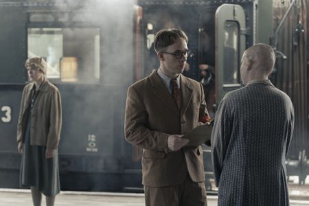 A SMALL LIGHT - Jan Gies, played by Joe Cole, speaks with a returning refugee at the train station as seen in A SMALL LIGHT. (Credit: National Geographic for Disney/Dusan Martincek)
