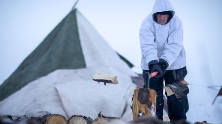 Chip Hailstone chops wood for their family camp in Kiwalik. (BBC Studios Reality Productions/Ashton Hurlburt)