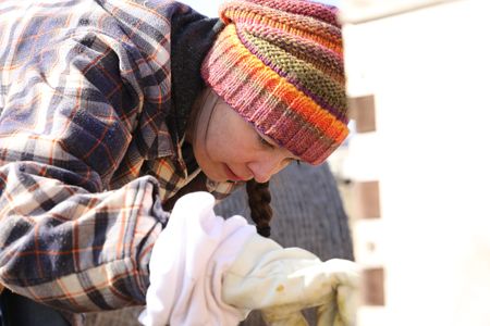 Beth Pol inspects the status of the Pol family's bee colonies now that winter has ended and it's springtime in Michigan. (National Geographic)