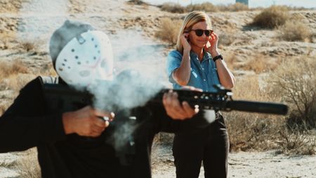 Dutch fires a ghost gun while Mariana plugs her ears. (National Geographic)