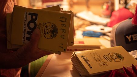 Conrad Anker holds his legendary climbing journals, including the one he kept while climbing Meru.  (National Geographic/Elena Gaby)