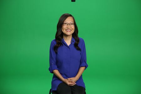 Helen Hong smiling and sitting Infront of a green screen. (National Geographic/Robert Toth)