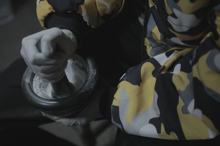 Sai crushing pure MDMA with a mortar and pestlel. (Credit: National Geographic)