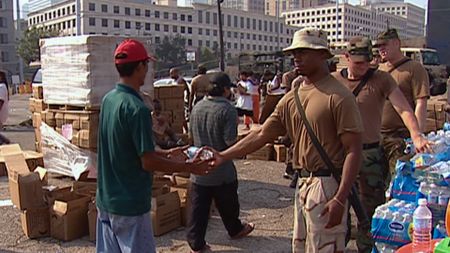 Members of the National Guard distribute water to New Orleans residents following Hurricane Katrina in 2005. (CNN)