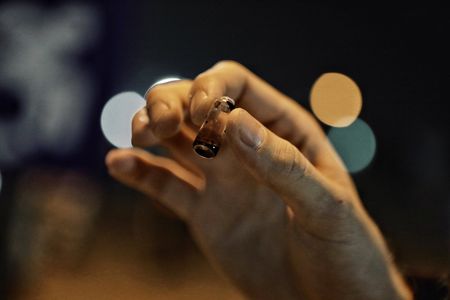 Mariana van Zeller holding a small bottle with dark liquid. (Credit: National Geographic)