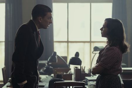A SMALL LIGHT - Tonny Ahlers, played by Bill Milner, pays a visit to Miep, played by Bel Powley, in the Opekta office as seen in A SMALL LIGHT. (Credit: National Geographic for Disney/Dusan Martincek)