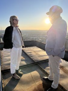 Mariana van Zeller and Ben discuss the world of scamming while on a rooftop in Johannesburg. (National Geographic for Disney)